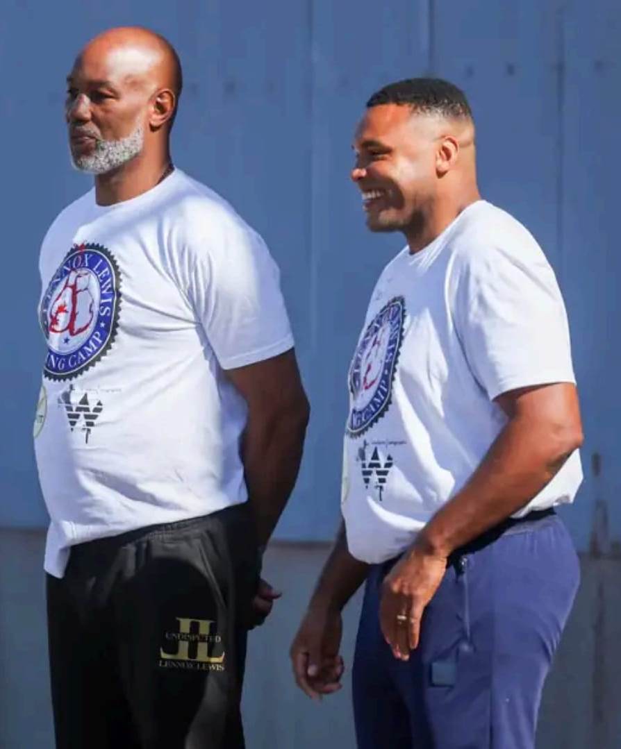 Deux employés d'ULUX en train de rire, en uniforme – image 1
